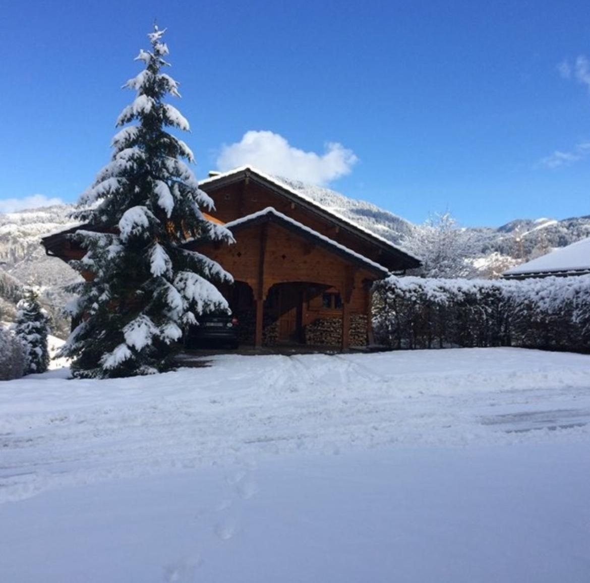 Chalet Olimon in winter snow, set against the forested mountains of Saint-Jean-d'Aulps